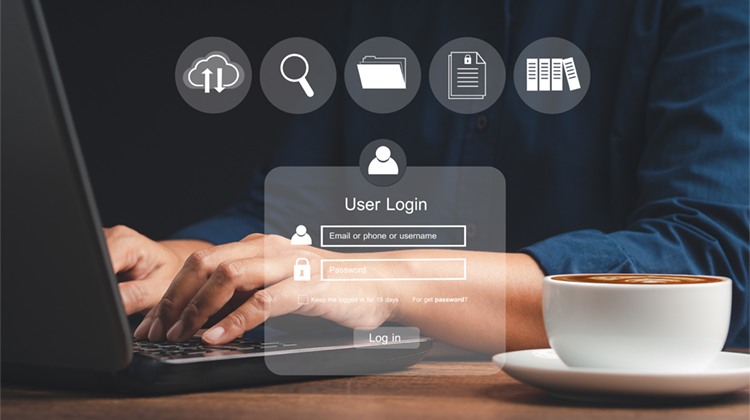 uomo che scrive al pc con a fianco una tazza di caffè