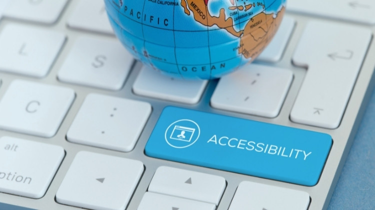 Tastiera di computer con un tasto azzurro personalizzato con la parola "Accessibility" e un piccolo globo terrestre.