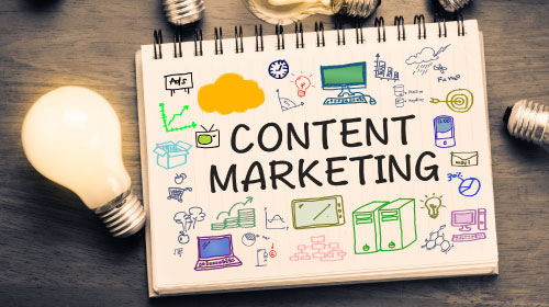 foto di un block notes con scritta content marketing e disegni che ricordano computer o altri accessori da ufficio