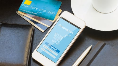 immagine che raffigura un cellulare con il simbolo di un carrello ecommerce e delle carte di credito