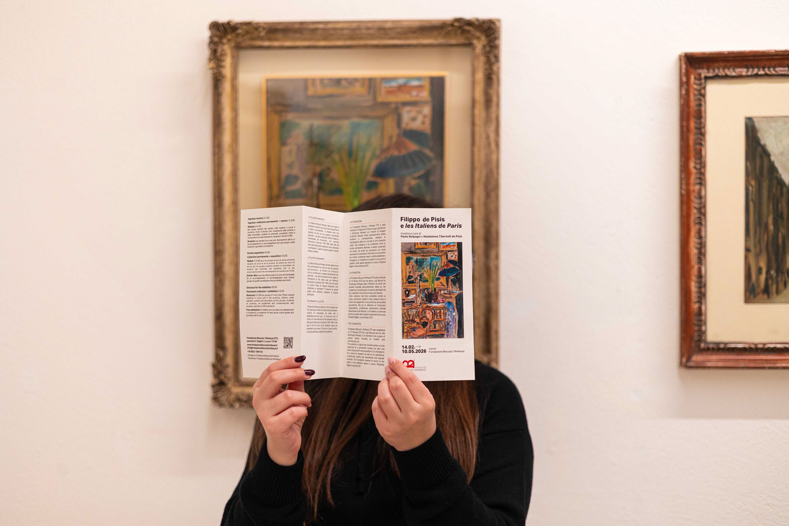 foto di una donna all'interno dell'edificio biscozzi con in mano la brochure