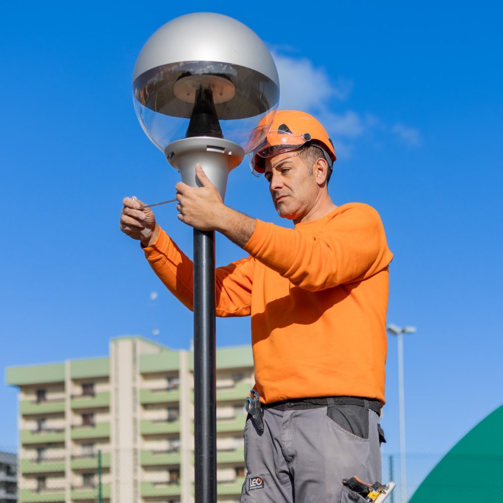 operaio monta palo della luce