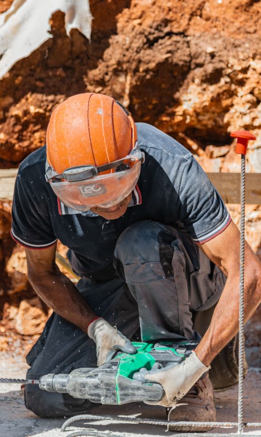 operaio in cantiere usa un trapano