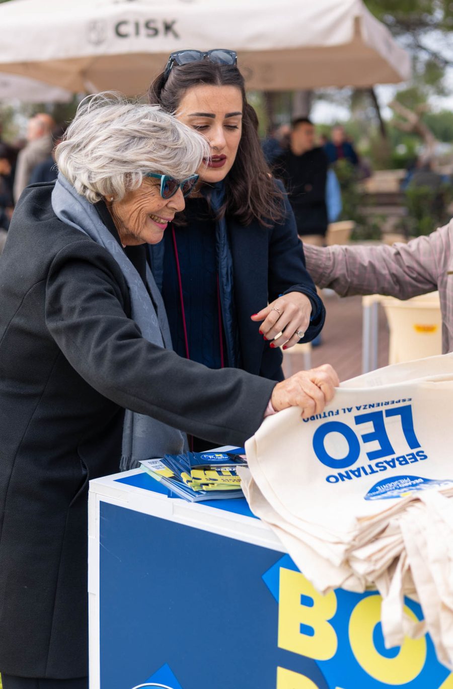 Foto di due donne che guardano i gadgets di Sebastiano Leo candidato al consiglio regionale della Puglia